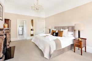 a bedroom with a large bed and a chandelier at Central Harrogate townhouse apartment with parking in Harrogate