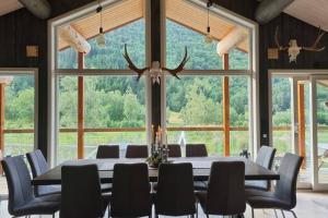 Cette grande chambre dispose d'une table, de chaises et d'une grande fenêtre. dans l'établissement Garasjeleilighet med kort vei til flott natur, Måndalen, Rauma, à Sæbø