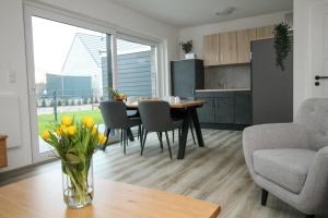 eine Küche und ein Wohnzimmer mit einem Tisch und Stühlen in der Unterkunft Ferienhaus Sonnenblick mit Sauna Harkebrügger See in Barßel