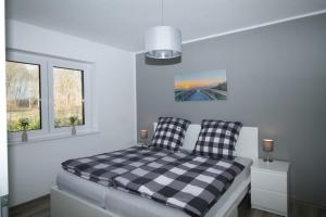 ein Schlafzimmer mit einem schwarz-weiß karierten Bett in der Unterkunft Ferienhaus Sonnenblick mit Sauna Harkebrügger See in Barßel
