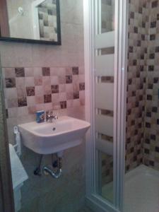 a bathroom with a sink and a shower at Pensión Vegadeo GIJÓN in Gijón