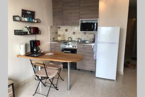 een keuken met een houten tafel en een koelkast bij Appartement T1 Balcon vue mer in La Ciotat