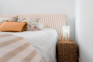 un letto bianco con cuscini e lampada sopra di Casa dos Infantes a Muros