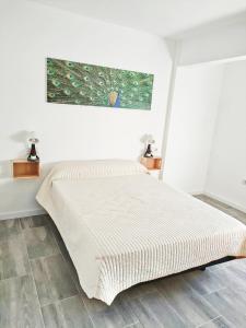 a bed in a bedroom with a painting on the wall at Estrella Polar in Tarancón