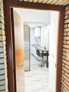 an open door leading into a kitchen with a desk at Estrella Polar in Tarancón