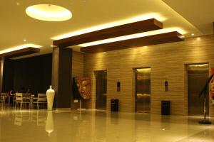 a lobby with a mask on the wall and a table at Crystal Lotus Hotel Yogyakarta in Yogyakarta