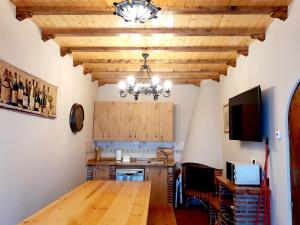 une cuisine avec une table en bois et un lustre dans l'établissement Adosado Marblés con Txoko y Wifi, à Ezcaray