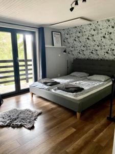 Schlafzimmer mit einem Bett und Holzboden in der Unterkunft Chata Lumira Bienska Dolina in Zvolen