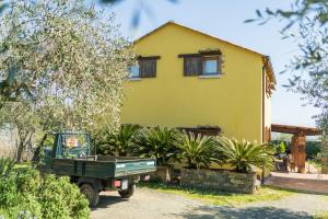 a yellow house with a green truck in front of it at Ara dei Pre, Terre Marine in Vezzano Ligure