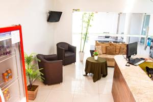 a living room with a couch and a desk with a computer at Hotel Portal dos Ventos in Parnaíba
