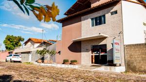 a building with a car parked in front of it at Hotel Portal dos Ventos in Parnaíba