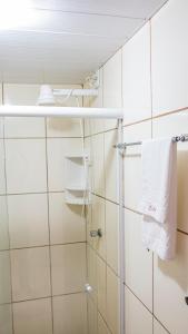 a bathroom with a shower with white towels at Hotel Portal dos Ventos in Parnaíba