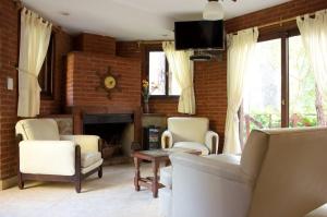 a living room with a couch and chairs and a fireplace at Acacias Blancas in Costa del Este