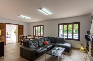 a living room with a leather couch and a table at Villa Sol in Alcudia