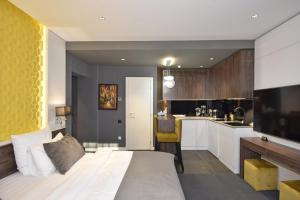 a bedroom with a large bed and a kitchen at Avenue ApartHotel in Yerevan