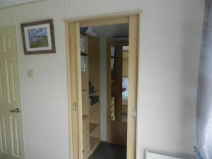 a closet with a door open to a room at Cwtch Caravans in Little Haven