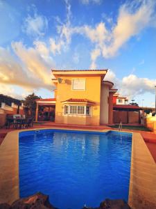 une maison avec une piscine en face d'une maison dans l'établissement Villa Nancy Tenerife Sur, à Granadilla de Abona