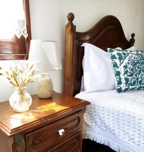 a bed with a table with a lamp on it at D'Oliva Gerês - River Side Houses in Geres