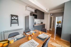 una cucina e una sala da pranzo con tavolo e sedie in legno di Lux Apartments a Zagabria