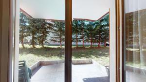 a sliding glass door with a view of a yard at Chesa Seraina Abitaziun Seraina 2 - Ivory - Madulain in Madulain