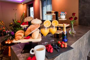 een tafel met brood en glazen sinaasappelsap en fruit bij Luxexcellent super suite in Nuland