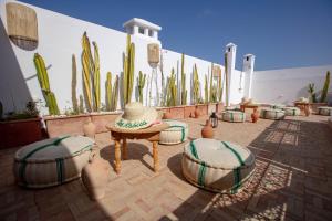 a patio with cactuses and a table and chairs at Riad Dar Rabiaa in Rabat
