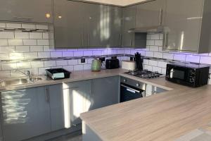 a kitchen with stainless steel cabinets and a microwave at Modern fully refurbished 3 bedroom home in Blackpool