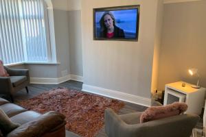 a living room with a flat screen tv on the wall at Modern fully refurbished 3 bedroom home in Blackpool