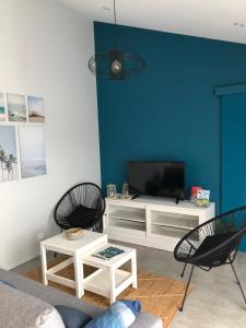 a living room with a tv and two chairs at Maison moderne avec jardin à 750m de la mer in Pornic