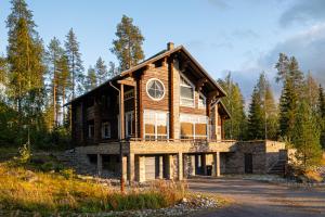 a large wooden house in the middle of a forest at Villa Cheers in Tahkovuori
