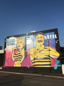 a billboard with a man and a woman painted on it at Hotel Restaurant Kyriad Brive Centre in Brive-la-Gaillarde