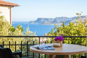 a table on a balcony with a view of the ocean at Hill House Adult Only in Kaş
