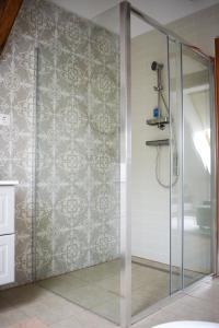 W łazience znajduje się prysznic ze szklanymi drzwiami. w obiekcie Puszedli w mieście Tata