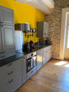 cocina con fogones y pared amarilla en Le Logis GOUT, en Carcassonne