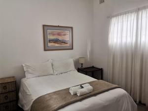 ein Schlafzimmer mit einem Bett mit zwei Handtüchern darauf in der Unterkunft Sani Window B&B and Self catering in Underberg