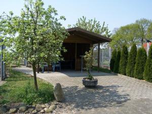 a pavilion in a garden with a tree at Ferienwohnung Mauer, Wohnung "C" in Heede