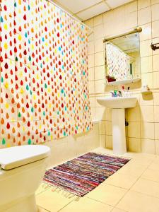 a bathroom with a shower curtain with a toilet and a sink at Woman ONLY-AnaRuby Backpackers-Mashreq Metro Station in Dubai