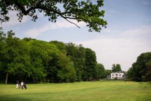 een groep mensen die over een weelderig groen veld lopen bij Landgoed Lauswolt in Beetsterzwaag