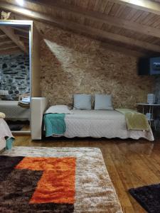 een slaapkamer met een bed en een stenen muur bij Refugio d'Anita Douro Valley House in Barcos