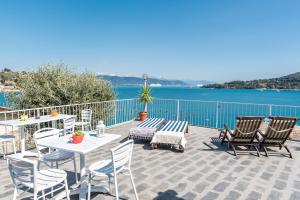 eine Terrasse mit einem Tisch, Stühlen und Wasser in der Unterkunft Affittacamere la Tortuga in Porto Venere