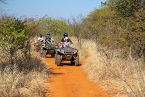 a group of people riding atvs on a dirt road at Sondela Nature Reserve & Spa Makhato Lodges in Bela-Bela