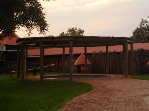 a wooden pavilion in a yard with a fence at Sondela Nature Reserve & Spa Makhato Lodges in Bela-Bela