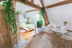 ein Wohnzimmer mit einem Tisch und einem Bett in der Unterkunft Au Zen Garden in Auxerre