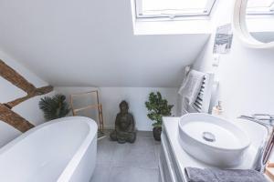 a bathroom with a white tub and a sink at Au Zen Garden in Auxerre +9 photos