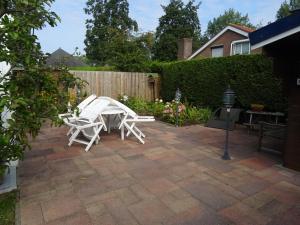 un patio con 2 sedie bianche e un tavolo di Kustverhuur, Park Schoneveld, Strandparel 365 a Breskens