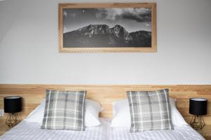 sypialnia z łóżkiem z obrazem na ścianie w obiekcie Tatrzańskie Spanie pokoje gościnne w Poroninie