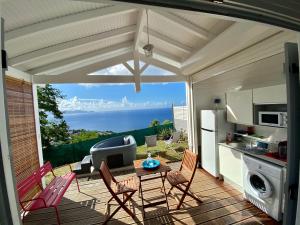 een keuken met een tafel en stoelen op een patio bij Bungalow Palbéa supérieur avec SPA et vue mer in Schœlcher