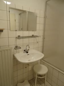 un bagno con un lavandino, uno specchio e uno sgabello di Kustverhuur, Park Schoneveld, Strandparel 365 a Breskens Altre 11 foto