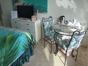 a bedroom with a bed and a table and chairs at Vista Room with a Sea View in Paignton