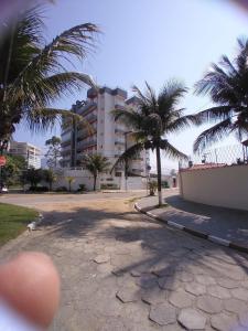 uma rua com palmeiras em frente a um edifício em terraços do maitinga em Bertioga